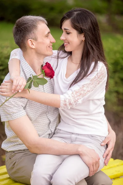 Couple embracing on bench — Stock Photo, Image