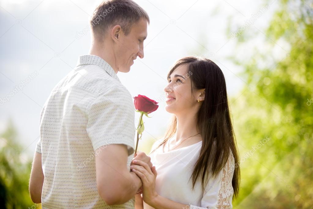 Young man giving flowers to girlfriend