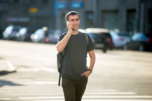 Young man on phone on pedestrian crosswalk — Stock Photo, Image