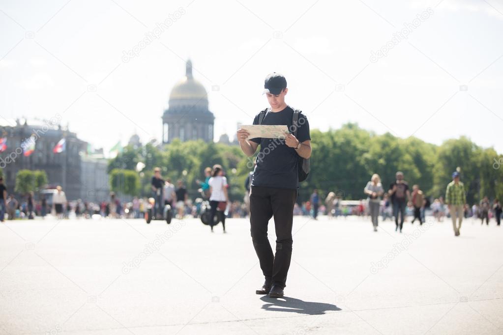 Young traveler with map in the street