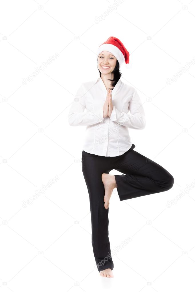 Young office woman in yoga pose in santa claus hat on white back