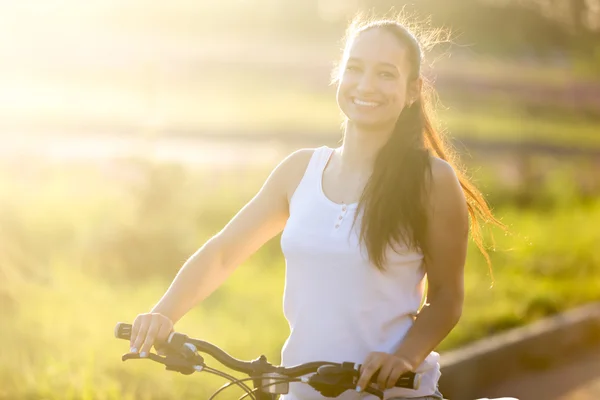 Jovem sorrindo asiático-caucasiano mulher de bicicleta — Fotografia de Stock