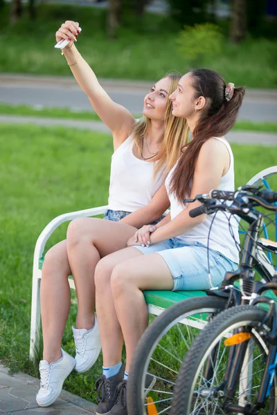 Cute young biker women taking self portrait in park — Stock Photo, Image