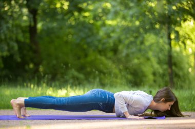 Chaturanga dandasana yoga pose in park alley