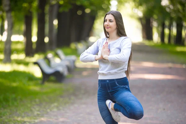Portrait of young woman standing in yoga tree pose — Stock Photo, Image