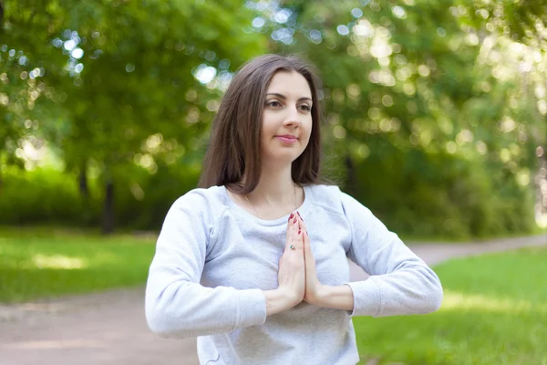 Mujer joven cogida de la mano en Namaste — Foto de Stock