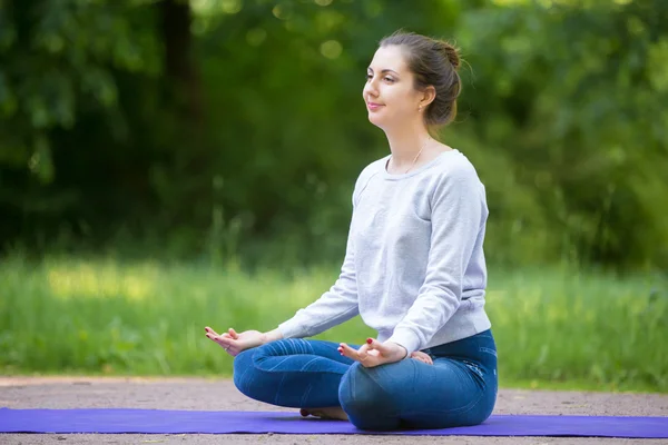 Smiling young woman meditating in park — Stock Photo, Image