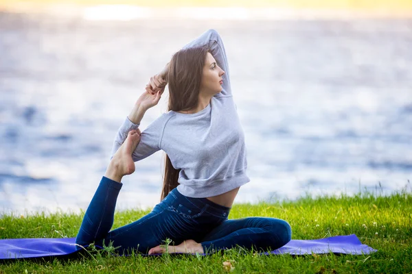 Hermosa joven deportista haciendo ejercicio en la orilla del río —  Fotos de Stock