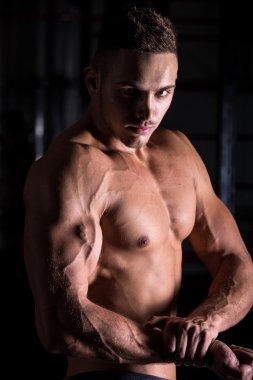Young bodybuilder showing brawny arm