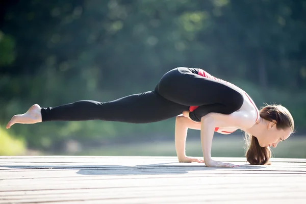 Teenage girl in Eka Pada Galavasana — Stock Photo, Image