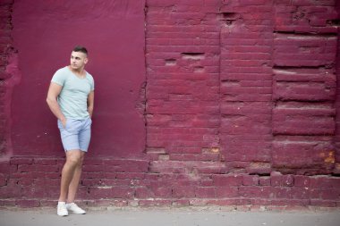 Young man portrait in front of brick wall