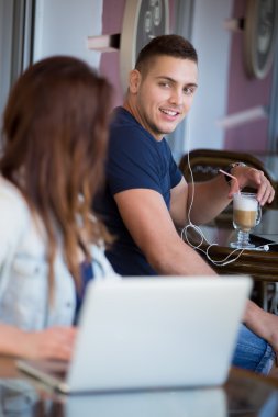 Smiling young man and woman in a cafe