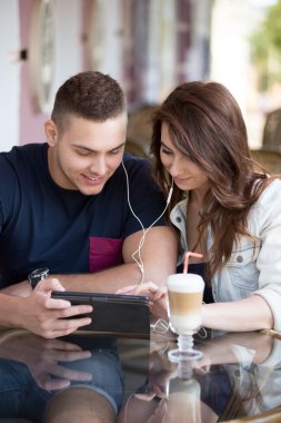 Couple using device at a cafe