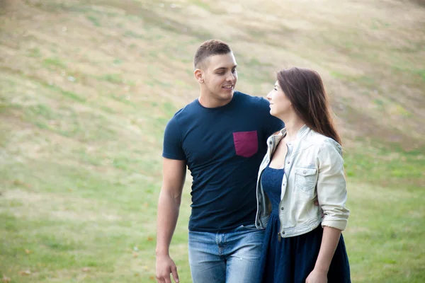 Joven hombre y mujer caminando en el parque — Foto de Stock