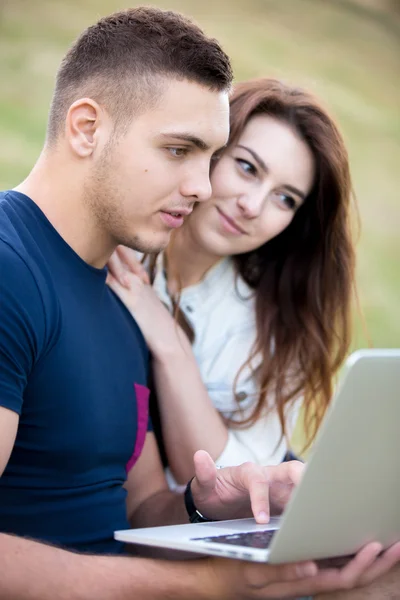 Couple working on laptop in park — Stok fotoğraf