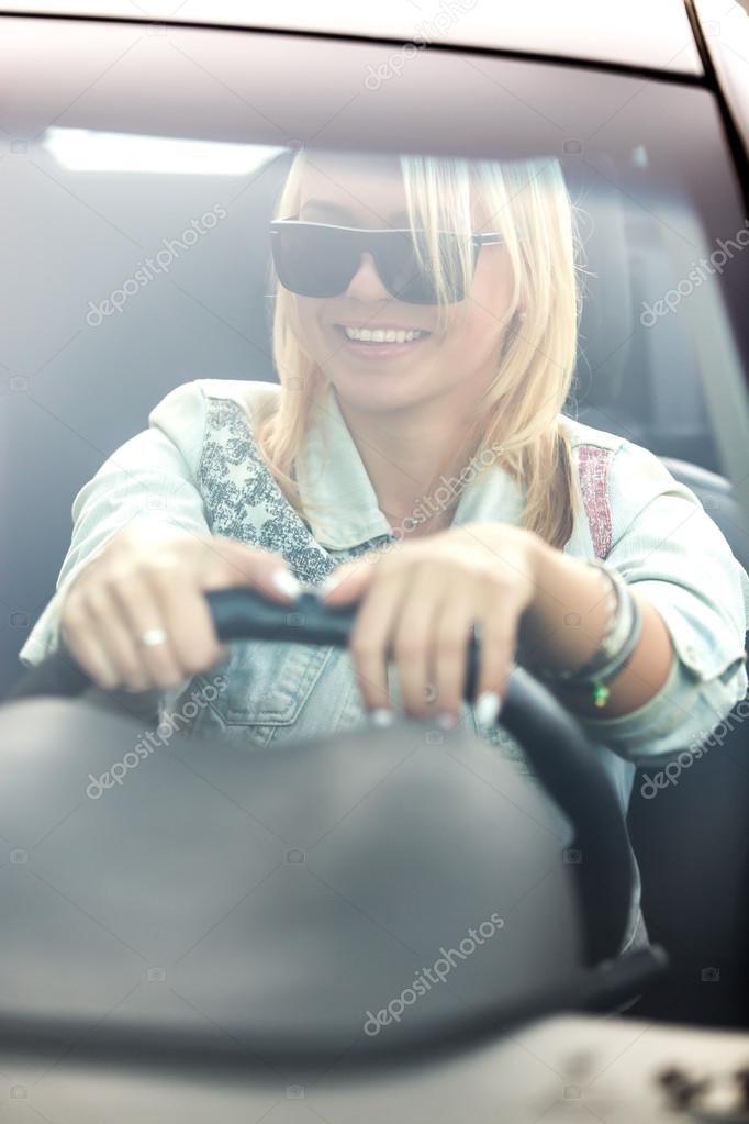Young cheerful woman driving