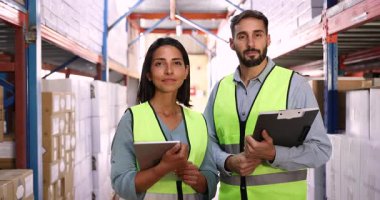 Portrait of smiling workers wear yellow safety vests stand in well-organized warehouse filled with stacked boxes and industrial shelving. Teamwork, professionalism in logistics or inventory management