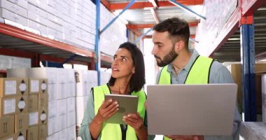 Two warehouse employees collaborating on inventory management