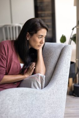 Pensive frustrated Hispanic woman suffering from apathy, melancholy, depression at home, thinking over health problems, going through emotional crisis, fatigue, burnout