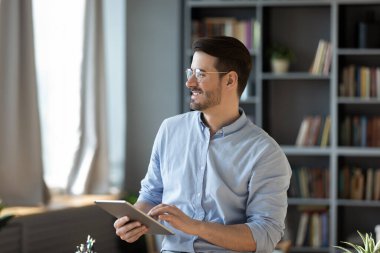 Digital daydreaming. Cheerful bearded young entrepreneur student scientist hold touchscreen device look aside from screen reflect on fresh concept for work study create new idea for research strategy