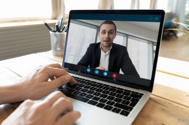 Online business meeting. Close up businessman sit at office desk by notebook talk to young man in formal suit on video call app. Digital collaboration virtual negotiations remote job interview concept