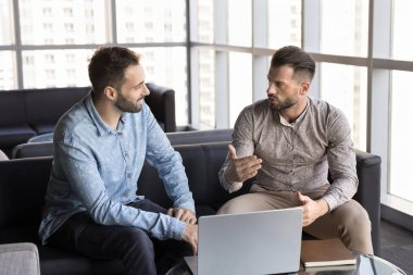 Ortaklık ve işbirliği. Farklı etnik geçmişlere sahip iki bin yıllık işadamı, dizüstü bilgisayarla yeni bir yaratıcı proje geliştirmeyi tartıştılar.