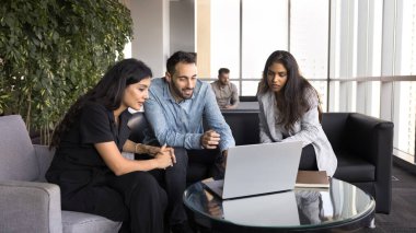 Yaşam planları için profesyonel yardım. Genç çift, samimi çalışma ortamında defter kullanarak ev alışverişini kadın seyahat acentesi emlakçısıyla tartışıyor.