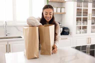 Mutfak konforu. Heyecanlı genç bayan ev hanımı, en sevdiği restorandan taze yemek getirmekten mutluluk duyar.