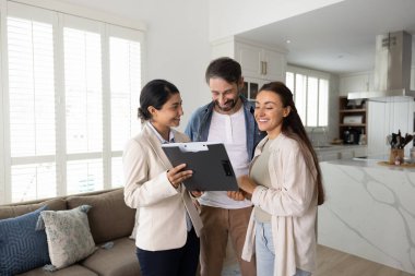 Dairenin yenilenmesini planlıyorum. Mutlu aile çifti ev sahipleri, yeni daire inceleme projelerinde kadın iç mimar profesyonel danışman ile tanıştı. Mobilya konforlu dekorasyon fikirleri tartıştılar.