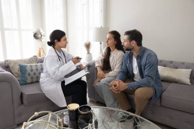 Kendine güvenen genç kadın doktor aile terapisti, doğurganlık danışmanlığı sağlamak için evli çifti ziyaret ediyor.