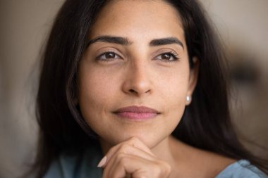 Yüzüne, çenesine, yüzüne dokunan, derin düşüncelerle gülümseyen, hayal kuran genç Latin kadının yüz portresini kapat. 30 'lu yaşlardaki güzel İspanyol kadının gizli bir fotoğrafı.