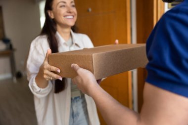 Eve teslim. Kesilmiş fotoğraf çeken gülümseyen kadın müşteri posta çalışanından karton bir kutuya doldurulmuş sevkiyat hediyesi alıyor. Güvenilir kurye şirketi ekommersi çevrimiçi alışveriş kavramı