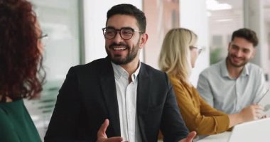 Neşeli, genç, yakışıklı Orta Doğulu iş adamı iş yerindeki çalışma masasında iş arkadaşlarıyla konuşuyor. Birkaç iş arkadaşı işbirliğini tartışıyor.