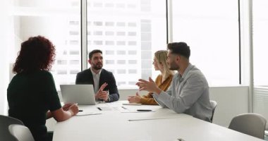 Genç Ortadoğu iş dünyası lideri hissedarlarla toplantı yapıyor, müzakere masasında patron yerine oturuyor, çalışanlarla konuşuyor ve kafa sallıyor.