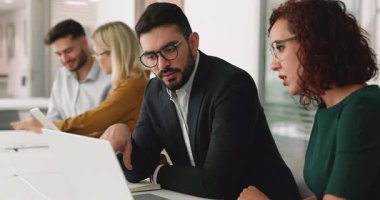 Bir kaç ciddi Orta Doğulu yönetici birlikte çalıştığı ofis odasında dizüstü bilgisayarda çalışıyor, online proje stratejisini tartışıyor, internetin içeriğini izliyor, ekranı işaret ediyor.