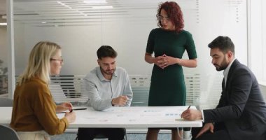 Çeşitli pazarlama ajansı personeli satış istatistik raporlarını analiz ediyor, analitik belgelerle masaya oturuyor, proje için iş stratejisi geliştiriyor, ürün satışları büyümesi