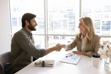 İki mutlu 30 'lu yılların iş ortağı toplantı masasında el sıkışıyor. Pozitif proje yöneticisi pazarlama danışmanına el sıkışırken, danışmanlık ve uzmanlık için teşekkür ederken,