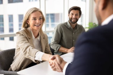 Mutlu sarışın İK yöneticisi kadın erkek aday işe alıyor, mülakat üstüne görüşme yapıyor, yüksek nitelikli profesyonelleri ağırlıyor. Omuz üstü görünümü