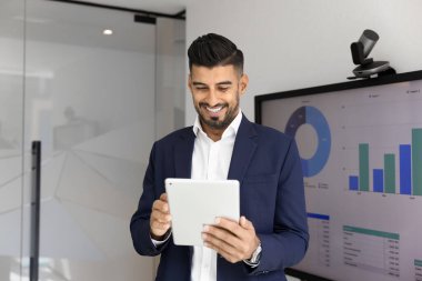 Pozitif Hintli finans müdürü şirket gelirini analiz ediyor, internet satış raporları yazıyor, sadece yönetim kurulundaki tablette daktilo yazıyor, iş başvurusunu pazarlama analizi için kullanıyor.