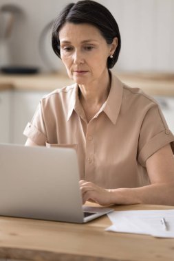 Çevrimiçi araştırma ve analiz. Ciddi iş kadını portresi dijital ve kağıt dökümanlarıyla evden bağımsız olarak çalışıyor pazarlama raporu not defterine yoğunlaşmış verileri analiz ediyor