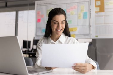 Ofis evrakları. Kendine güvenen genç iş kadını muhasebeci proje geliştirici veri geliştirici kağıt belgeleri inceleme finans raporları iş yerindeki pazarlama araştırmaları için bilgiyi analiz ediyor