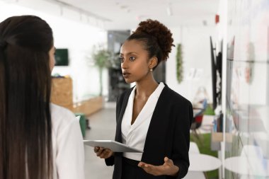 İş görüşmesi. Resmi takım elbiseli genç bayan İK yöneticisi işe alım toplantısında kadın adaya hitaben yaptığı konuşmada iş taleplerini potansiyel işe alma beklentilerini açıklıyor. Boşluğu kopyala