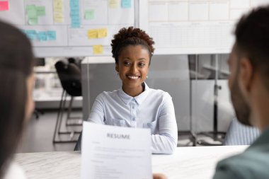 Başarı için hazır. Kendine güveni tam genç bir kadın profesyonel iş adamı masasına oturuyor. İK yöneticilerine cevap veriyor. Görüşme sırasında kendini tanıtıyor.