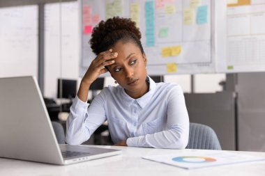 Zihinsel engelleme. Mutsuz genç kadın stratejist muhasebeci ofiste dizüstü bilgisayarın başında oturur ekrandan başka tarafa bakar zor problemi çözemez yaratıcı kriz stresi motivasyon eksikliği hisseder