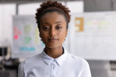 Kendine güvenen bir iş kadını. Güzel, genç iş kadını portresi. Yönetici pozisyonu. Sakin ve ciddi bir yüzle kameraya bakın.