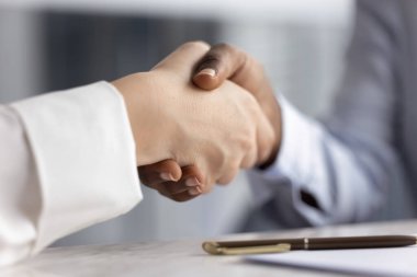 Başarılı bir ortaklık. Yakın mesafeden iki farklı genç kadın iş adamı sözleşmeyi imzaladıktan sonra el sıkıştı. Yasal anlaşmanın onaylanması b2b işbirliği ticari başarı anlaşması konsepti