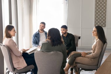 Modern ofiste daireler çizen çeşitli çalışanlar, gülen ve birbirini dinleyen katılımcılar, dostça ve açık bir sohbet, grup koçluğu ya da beyin fırtınası oturumu. Takım oluşturma