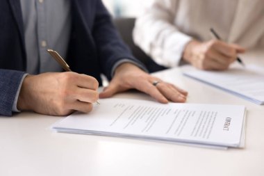 Ortakla, yatırımcıyla, proje satıcısıyla veya alıcısıyla görüşme sözleşmesi imzalayan, ofis masasına kağıt döküman yazan, imza atan, işbirliğine başlayan işadamlarının eli. Kırpılmış atış