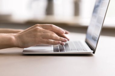 Laptop kullanıyorum. Masada not defterine yazı yazan kadın elleri kesilmiş. Uzak serbest çalışma mesafesi e karışık eğitim elektronik metin yazma içeriği oluşturma dijital ağ kavramı