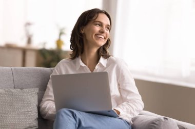 Dijital ilham anı. Hoş gülümseyen genç bir kadın evde defter ile rahat vakit geçirir çevrimiçi sohbet içeriği araştırmasına ara verir online fikirlerden esinlenerek gelecek tatil planını hayal edin.